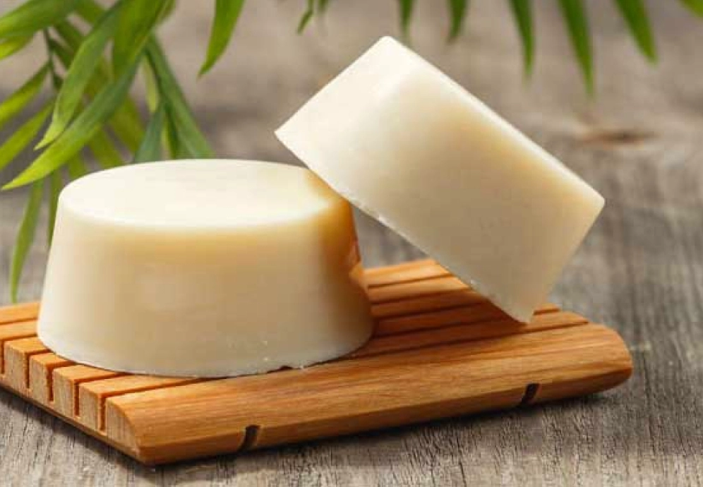 rondelle de shampoing solide naturel beige sur porte savon en bois